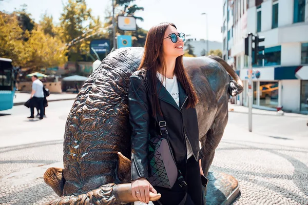 Donna che indossa occhiali da sole in piedi alla statua — Foto Stock