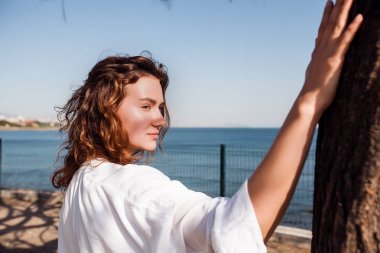 Kız ağaç deniz kenarında yanında ayakta