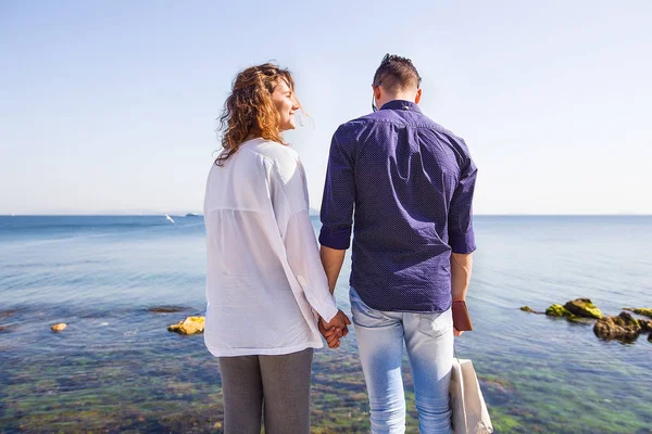 Pareja joven de pie junto al mar — Foto de Stock