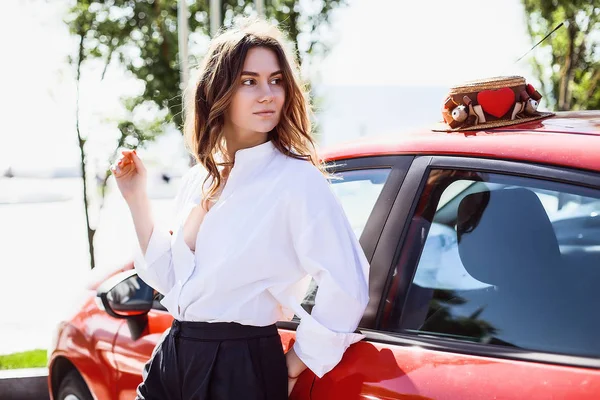Женщина стоит рядом с автомобилем на открытом воздухе — стоковое фото
