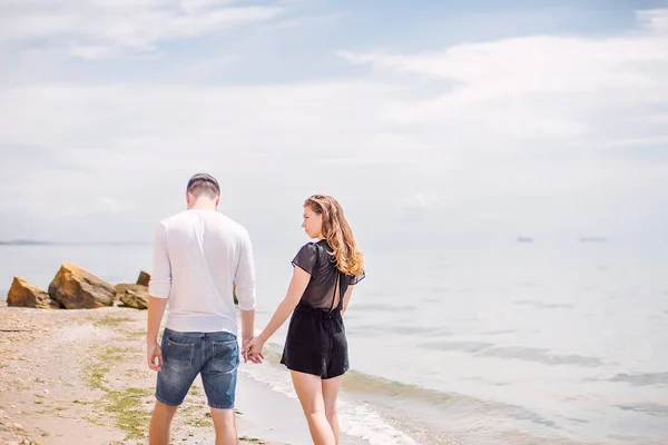 Pareja caminando en la costa del mar — Foto de Stock