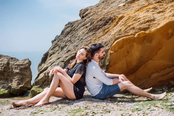 Couple sitting on sea coast — Stock Photo, Image