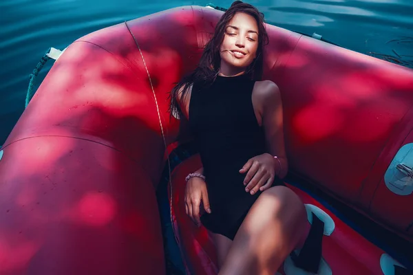Vacker kvinna i röd uppblåsbar båt — Stockfoto