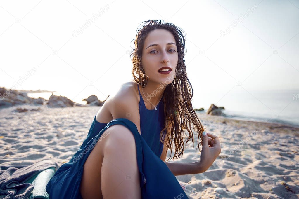 woman with wet hair sitting on beach