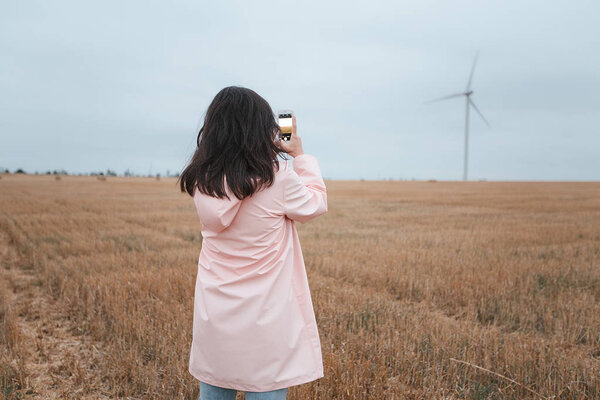 girl in raincoat in autumn field