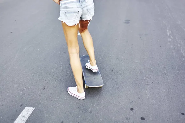 Mulher jovem com skate — Fotografia de Stock