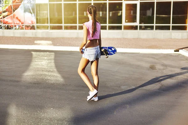Молодая женщина со скейтбордом — стоковое фото