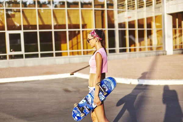 Jonge vrouw met skateboard — Stockfoto