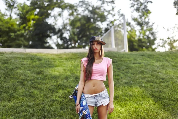 Jonge vrouw met skateboard — Stockfoto