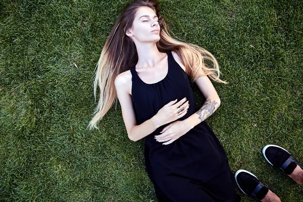 Junge schöne Frau auf dem Gras liegend — Stockfoto