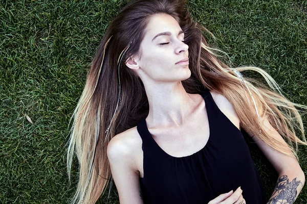 Молодая красивая женщина, лежащая на траве — стоковое фото