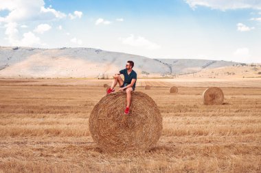 Samanlık üzerinde oturan adam