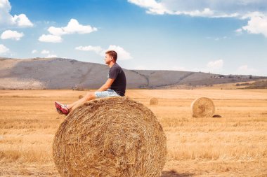 Samanlık üzerinde oturan adam