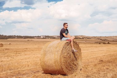 Samanlık üzerinde oturan adam