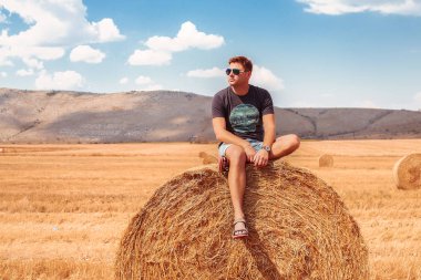 Samanlık üzerinde oturan adam