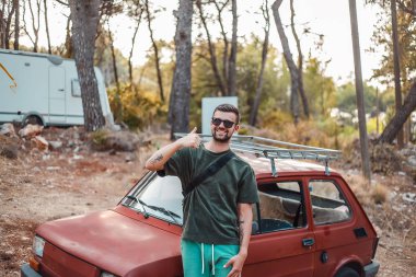 eski arabanın yakınında duran adam