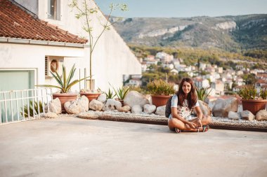 Kız açık havada oturup sırt çantası ile