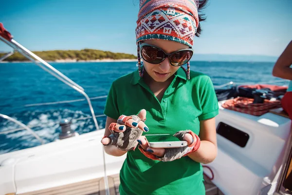 Young woman yachting with phone — Stockfoto