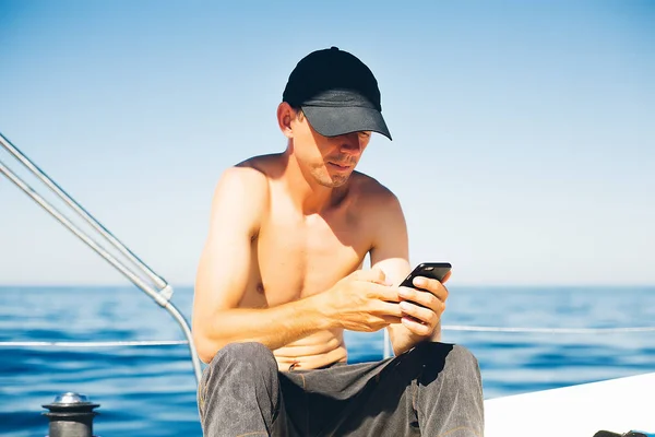 man  on the yacht with phone