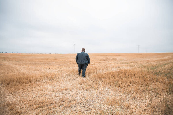 молодой бизнесмен, стоящий на пашне
