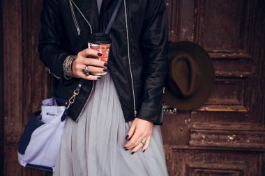 kadın ayakta tutan Kupası kahve ahşap kapı arka plan üzerinde kırpma