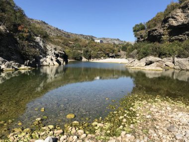 Gündüz vakti ormanla kaplı dağların arasındaki sığ göl manzarası 