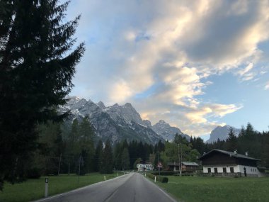 Gündüz vakti dağların arasında boş yolu olan köyün resimli görüntüsü 