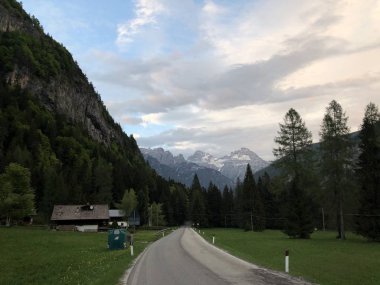 Gündüz vakti dağların arasında boş yolu olan köyün resimli görüntüsü 