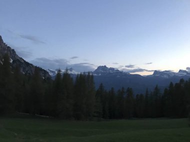 Gün batımında ormanla kaplı dağların manzarası. 