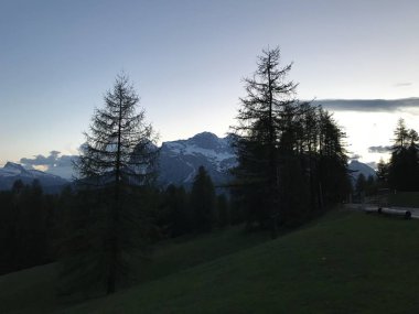 Gün batımında ormanla kaplı dağların manzarası. 