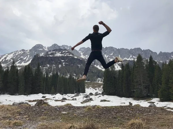 Vue Arrière Voyageur Mâle Sautant Parmi Les Montagnes Enneigées Couvertes — Photo