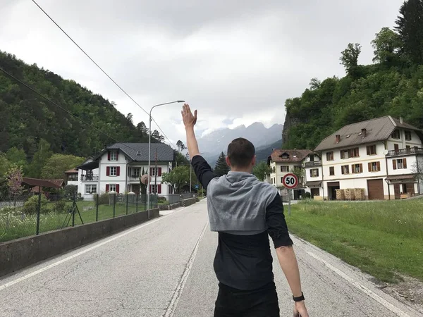 Zpět Pohled Mužského Cestovatele Kráčejícího Prázdné Silnici Obci Mezi Horami — Stock fotografie