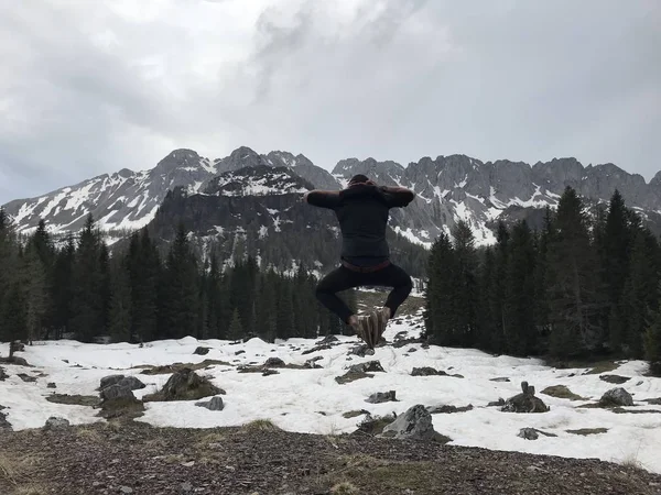 Vue Arrière Voyageur Mâle Sautant Parmi Les Montagnes Enneigées Couvertes — Photo