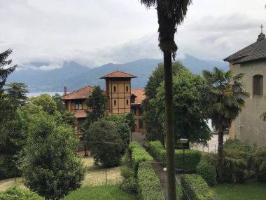 Güzel eski bina manzarası ve arkasında dağlar olan yeşil bahçe. 