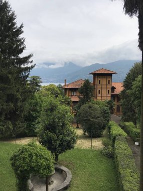 Güzel eski bina manzarası ve arkasında dağlar olan yeşil bahçe. 