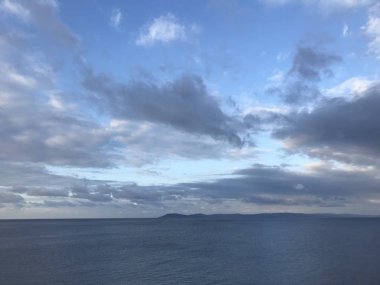 bulutlu bir günde sakin deniz yüzeyi manzarası