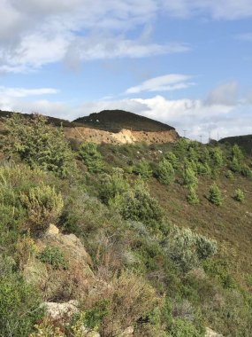 mavi gökyüzü arkaplanındaki yeşil tepelerin resimsel görüntüsü 