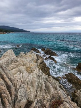 Turkuaz deniz suyunun vahşi deniz kıyısı ve sahile ulaşan dalgaların manzarası. 