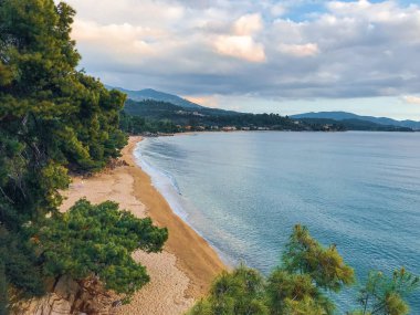 Turkuaz deniz suyunun vahşi deniz kıyısı ve kumlu sahile ulaşan dalgaların manzarası. 