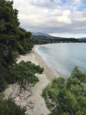 Turkuaz deniz suyunun vahşi deniz kıyısı ve kumlu sahile ulaşan dalgaların manzarası. 