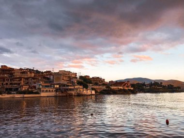 Yaz günbatımında deniz kıyısındaki şehir manzarası. 