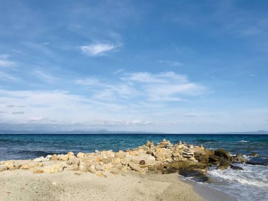 Turkuaz deniz suyunun vahşi deniz kıyısı ve kumlu sahile ulaşan dalgaların manzarası. 