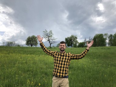 Yaz günü dağların arasında yürüyen sıradan giysili yakışıklı bir adam.  