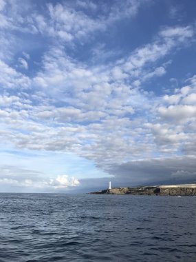 Deniz fenerinin yaz günü kayalık sahil ve deniz manzarası