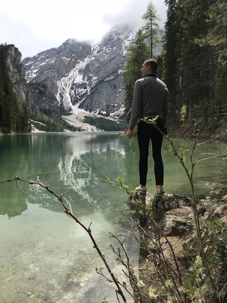 Visão Traseira Viajante Masculino Costa Lago Entre Montanhas Cobertas Com — Fotografia de Stock