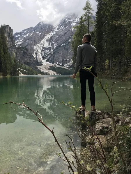 Visão Traseira Viajante Masculino Costa Lago Entre Montanhas Cobertas Com — Fotografia de Stock