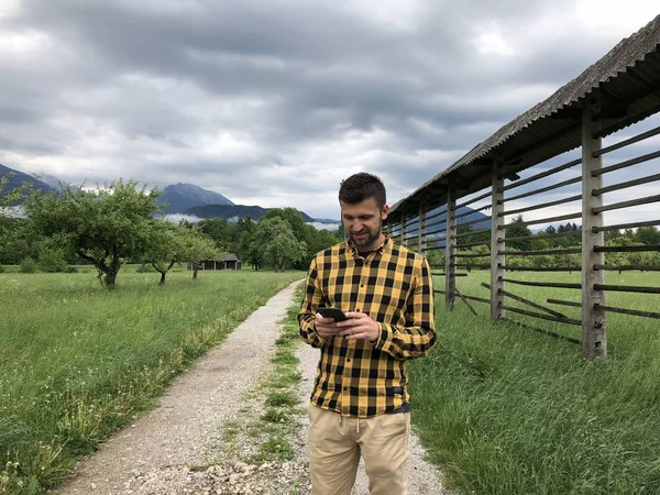 Homem Bonito Roupas Casuais Usando Smartphone Entre Montanhas Dia Verão — Fotografia de Stock