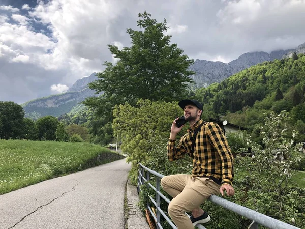 Homem Sentado Cerca Ponte Falando Smartphone Entre Montanhas Cobertas Com — Fotografia de Stock