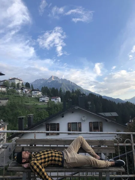 Mann Freizeitkleidung Ruht Auf Holzbank Auf Aussichtsplattform Dorf Mit Bergblick — Stockfoto