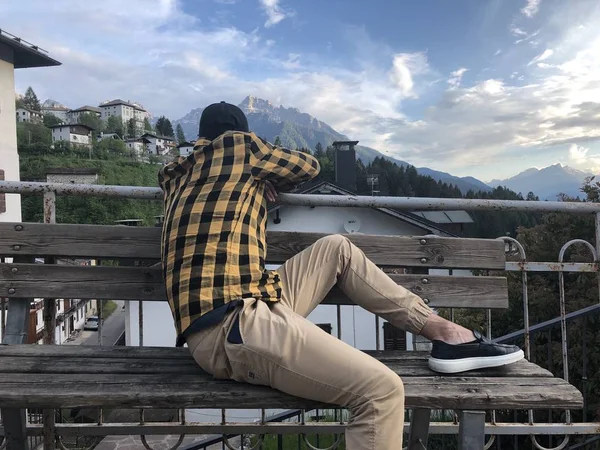 Mann Freizeitkleidung Ruht Auf Holzbank Auf Aussichtsplattform Dorf Mit Bergblick — Stockfoto